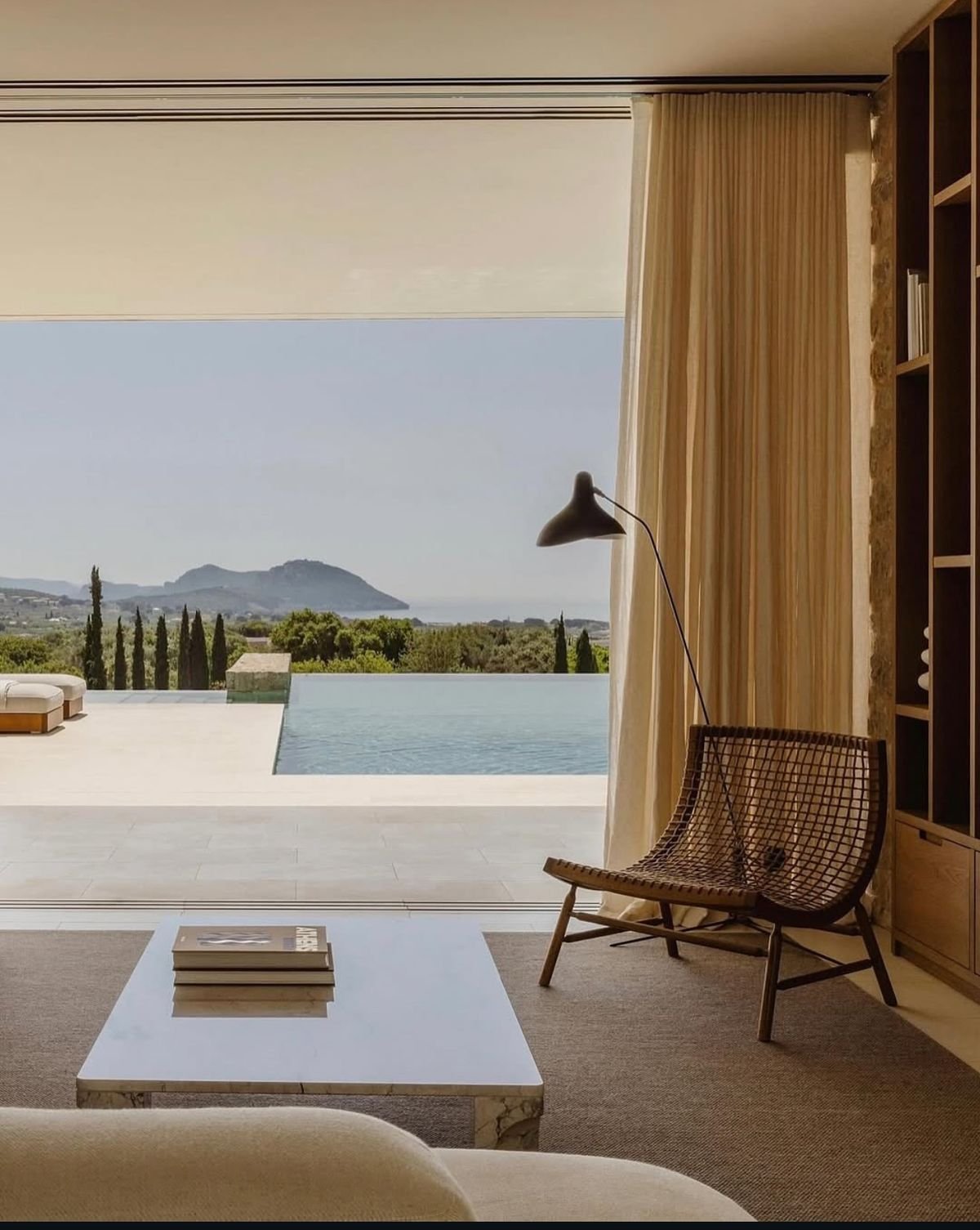 Bespoke web design for extraordinary homes featuring a designer lounge chair and private infinity pool.