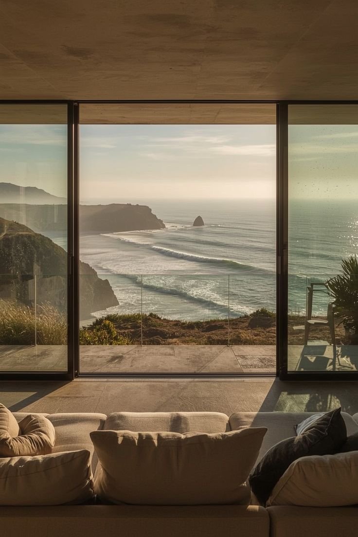 Serene interior design of a luxury coastal home featuring floor-to-ceiling windows and ocean views.